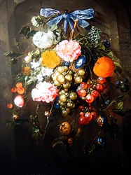 Ett stilleben av blommor och frukter bundet med en blå rosett