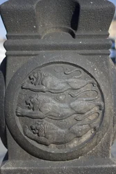 Tre lejonsymbol huggen i en stenpelare på Rådhustorget