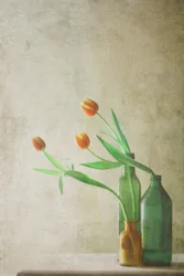 Orange tulpaner i flaskor