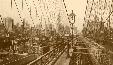 Lower Manhattan sett genom nätverket av kablar på Brooklyn Suspension Bridge, c1930.