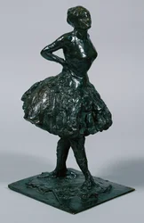 Dansare i ledig klänning, händerna på höfterna, höger ben framåt, gjuten ca 1919-21