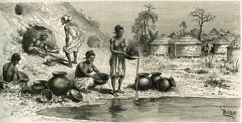 Kvinnor i byn Koumakhana tvättar guld, i bakgrunden söker män guld i underjordiska gallerier. Gravyr av Riou, för att illustrera berättelsen "Exploration du Haut-Niger (Haut-Niger)" (nuvarande Mali) av befälhavare Joseph Gallieni (1849-1916) från