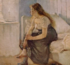 Flicka sitter på sängkanten