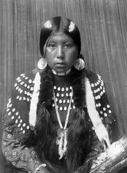 Kalispel indisk kvinna, vita ränder målade på håret, örhängen med skalskivor, klädd filtklänning dekorerad med älgtänder, ca. 1910, foto Edward S. Curtis