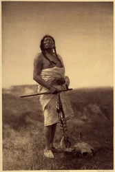 Manlig läkare. Förmodligen har Sioux, bläckfisk i handen och buffelskalle sina fötter. Foto taget från volym 3 av Edward S. Curtis uppslagsverk (1868-1952) om nordamerikanska indianer, med ett förord av Theodore Roosevelt. Mellan 1907 och 1930 var 20 volym