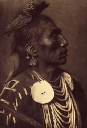 Medicinkråka, Apsaroke. Falken som är bunden till huvudet är ett sätt att bära symbolen för sin skyddsanda. Foto taget från volym 4 av uppslagsverket publicerat av Edward S. Curtis (1868-1952) om indianerna i Nordamerika, med ett förord av Theodor