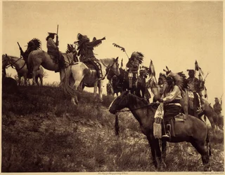 Planerar en razzia. Indianerna, i sina imponerande typiska dräkter, samlas i extremt pittoreska grupper. Det här är en trupp från Sioux Ogalala (Oglala), på en kulle med utsikt över Wounded Knee Valley i Pine Ridge Reserve, South Dakota. Foto tak