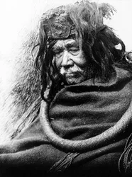 Hamatsa, Nakoaktok c. 1910 Halvlängd porträtt av Nakoaktok Man, som vänder mot vänster, bär cederemonial slinga.