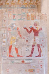 Basreliefbild som visar farao (till höger) som ger offer till guden Horus, Hatshepsut-templet i Deir Al Bahari, Luxor, Egypten (foto)