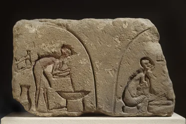 Sandstensrelief vid beredning av en måltid (sandsten)