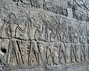 Figurer som symboliserar gruvdistrikt som för sina hyllningar till gud, relief, Ramses II:s innergård, Amuntemplet (Unescos världsarvslista)