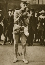 En skådespelare utklädd till Houdini utanför en teaterdörr (sepiafoto)