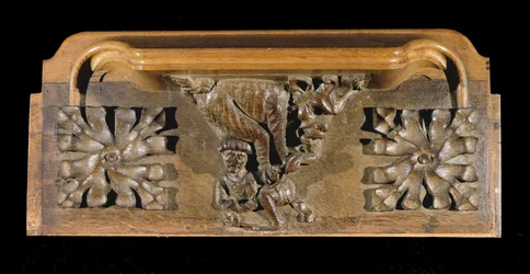 En misericord som föreställer en liten figur med lock som kastades på av ett monster, New College Chapel, Oxford, sent 1300-tal (trä)