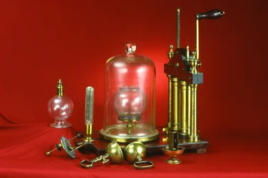 Dubbelpipig luftpump, försedd med olika demonstrationsexperiment inklusive guinea och fjäder, magdeburgska halvklot, klocka i vakuum och kollapsande blåsa, ca 1800
