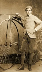 Man stående bredvid sin höghjuling, cirka 1890