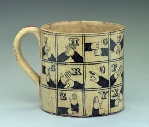 Staffordshire-mugg föreställande alfabetet på teckenspråk, ca 1820 (lergods)