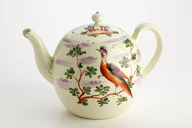 Staffordshire tekanna dekorerad med exotiska fåglar och byggnad bland träd, ca. 1765-75 (creamware)