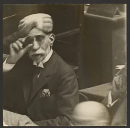 [Sittande man i turban och mörka glasögon]
