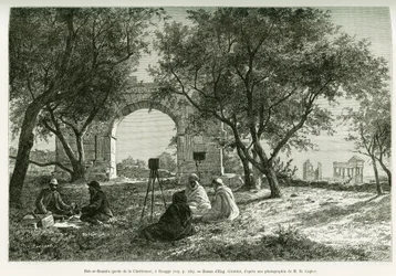 Bab-er-Roumia (Bab er Roumia), den kristna kvinnans port, romerska ruiner i Dougga, resenärer och deras guider på picknick runt en kamera. Gravyr av Eugène Girardet som illustration till berättelsen ”Voyage en Tunisie” av R. Cagnat och H. Saladin