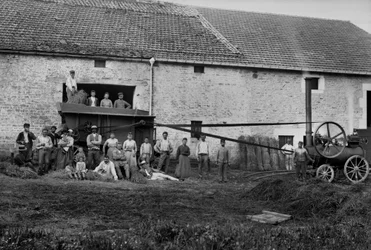Jordbruksarbetare och press band knöt stövlar på en gård nära Bourmont i Haute-Marne (Haute Marne), omkring 1890. Fotografi. Ducos samling.