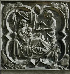 Adam lagar mat medan Eva, i sängen, tar hand om ett barn ... (relief)