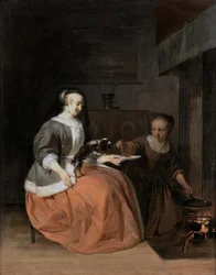 Ung kvinna och tjänsteflicka matar en hund med en pannkaka
