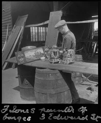 Frank Jones i arbete med att måla en dekorativ panel, 1900-talet (foto)