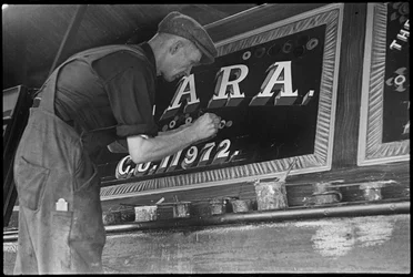 Frank Jones, i arbete med att måla namnpanelen på en pråm, 1900-talet (foto)