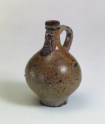Bartmannkrug eller Bellarmine vinflaska dekorerad med en applicerad skäggig ansiktsmask, Tyskland, ca 1630-40 (saltglaserat stengods)