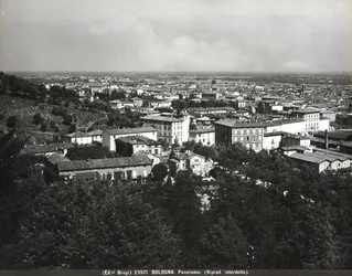 Panorama över Bologna med några fabriker och en kulle.