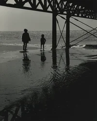 Två barn leker på stranden.