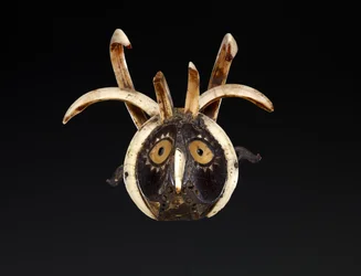 Munmask som troligen föreställer huvudet på en tupp (trä, vildsvinsbetar, musselskal, pärlemor, buffelhorn, hartsartat material och pigment)