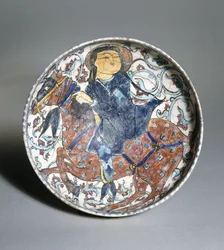 En mina"i skål föreställande en riden ryttare omgiven av en blommig design, ca 1200
