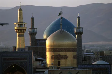 Den helguld kupolen och minareten i Imam Rezas helgedom, den 8:e shiitiska imamen, med Timurid Gowhar Shad-moskén bakom