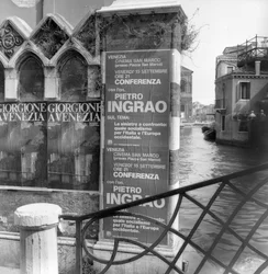 Utsikt över en kanal i Venedig med affischer som annonserar en Giorgione-utställning och ett politiskt manifest i förgrunden