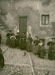 Kvinnor och barn i traditionella kläder på trappan upp till ett hus, Abruzzo, Italien