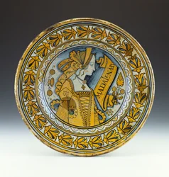 Ett Deruta-porträttfat i blått och guld som föreställer en ung kvinna i profil och inskrivet Madalena B, c.1525 (lustred keramik)
