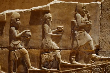 Reliefskulptur av män som bär offergåvor på väggarna i Persepolis. Persepolis, Iran.