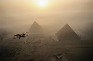 Veteranflygplanet Vimy flyger över dimhöljda pyramider under en gyllene solstråle...