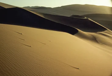 Vy över skarpt avtecknade skuggiga sanddyner nära Dunhuang. Gansu-provinsen, Folkrepubliken Kina.