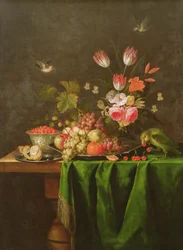 Stilleben med frukt och blommor med en papegoja på ett bord täckt med en grön duk