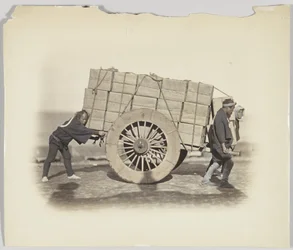 Män som drar en vagn (handfärgat svartvitt foto)