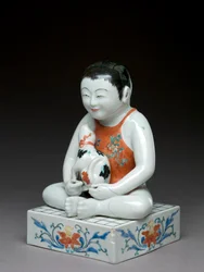 Pojke med en hund som sitter på ett fyrkantigt shogibord, Kakiemon-relaterat porslin, japanska, 1680-1700 (lergods med blå underglasyr)