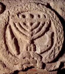 Judendom: arkitektoniskt element i basalt av en synagoga dekorerad med en ljusstake med sju grenar (menora eller menora), palm och trumpet. Från Transjordan. Omkring 100 e.Kr. Paris, Louvren