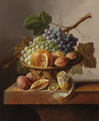 Vindruvor, en apelsin och valnötter i en flätad korg med en citron och plommon, allt på en marmorkant