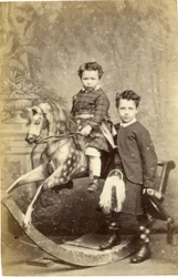Ung flicka på gunghäst med ung pojke i kilt, 1860-talet (albuminprint)