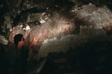 William Saturno inspekterar väggmålning; San Bartolo; Guatemala; Maya, 2002 (foto)