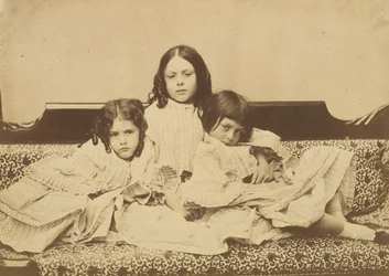 Edith, Ina och Alice Liddell på en soffa, sommaren 1858.