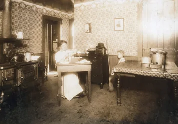 Kvinna som sätter in borst i tandborstar i sitt kök, ca 1912