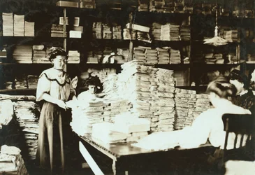 Unga kvinnor sorterar papper i ett förråd, ca 1905